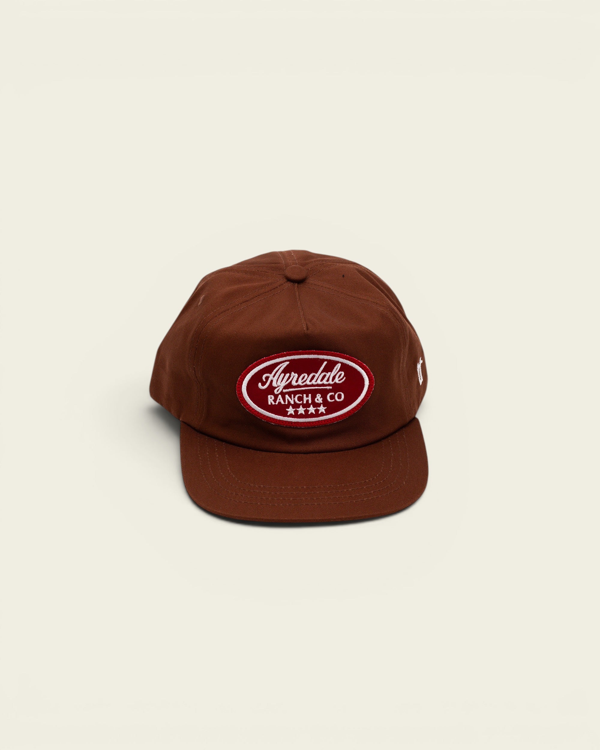 Ayredale Ranch & Co brown baseball cap with a red oval patch featuring white embroidered text and four stars