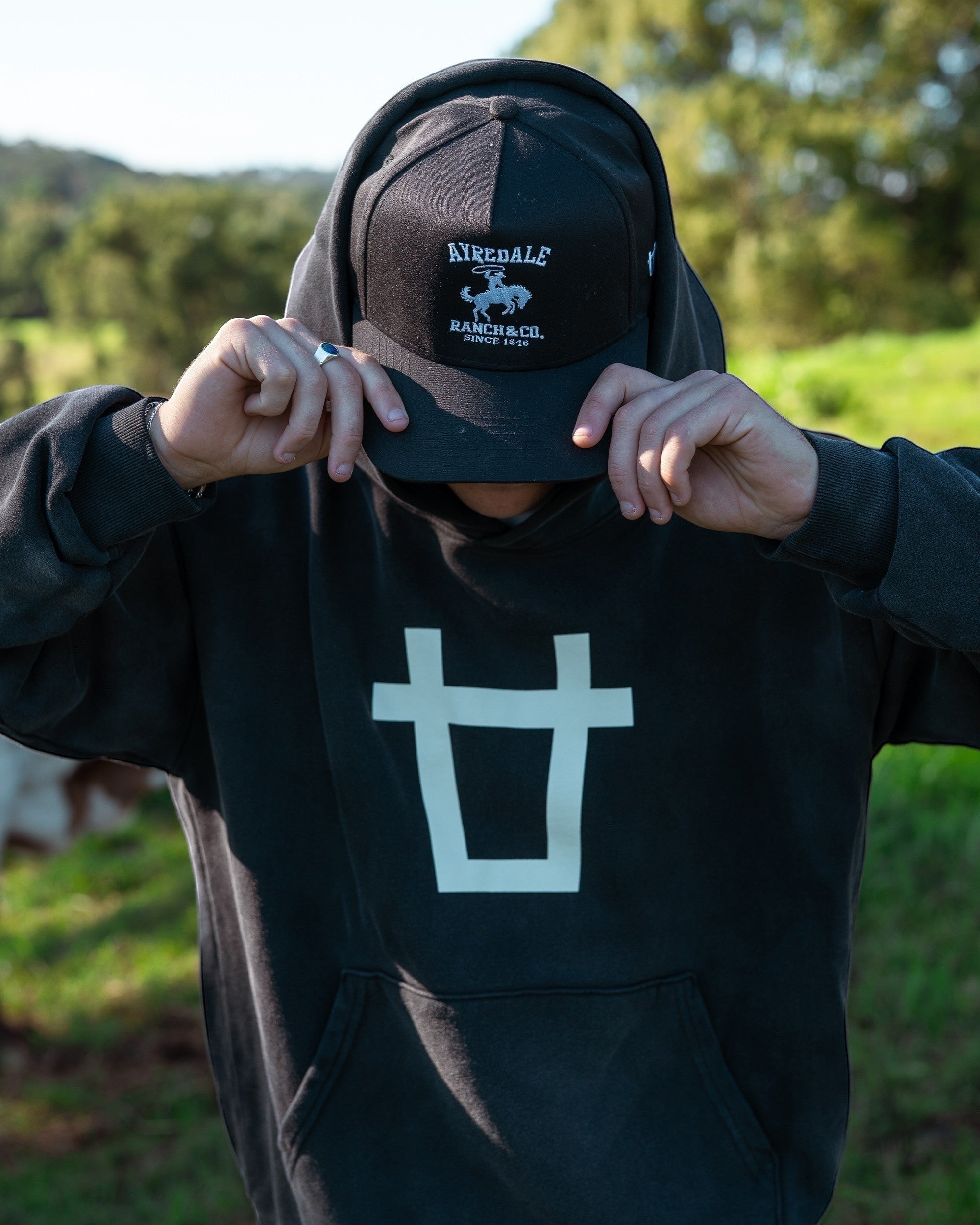 Ayredale Ranch & Co black heavyweight fleece hoodie with oversized white chest logo and matching baseball cap.