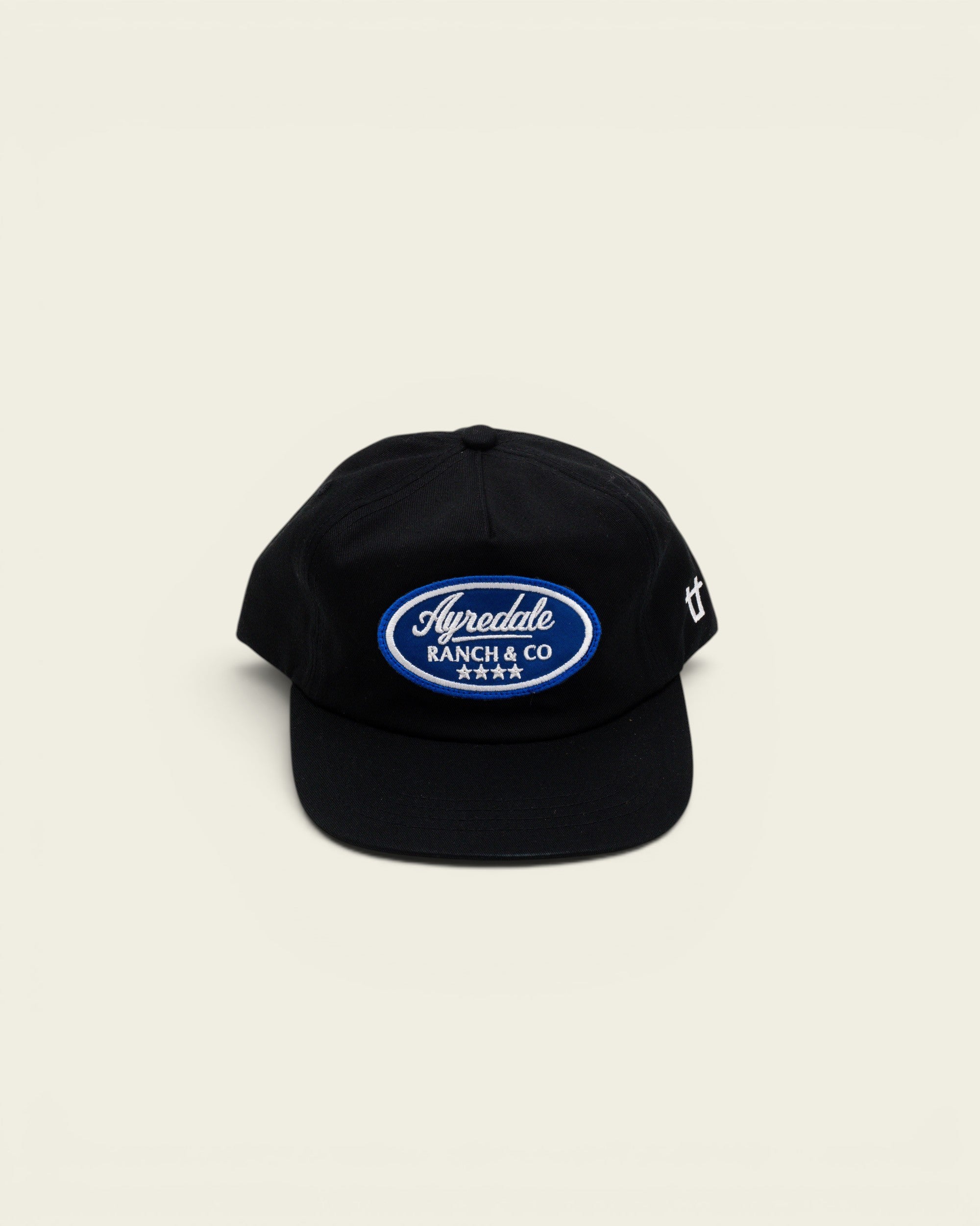 Ayredale Ranch & Co black baseball cap with a blue oval embroidered patch logo and four stars on the front
