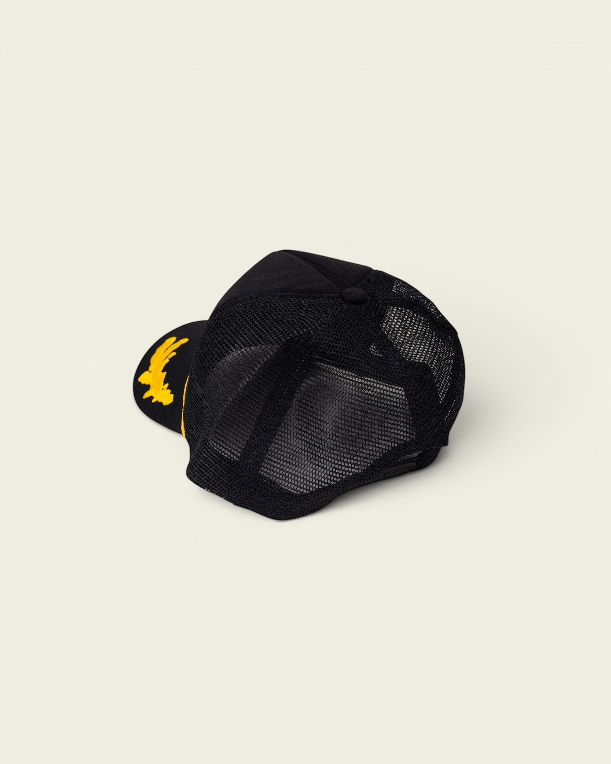 Ayredale Ranch & Co black trucker hat with yellow eagle embroidery on the front and mesh back.