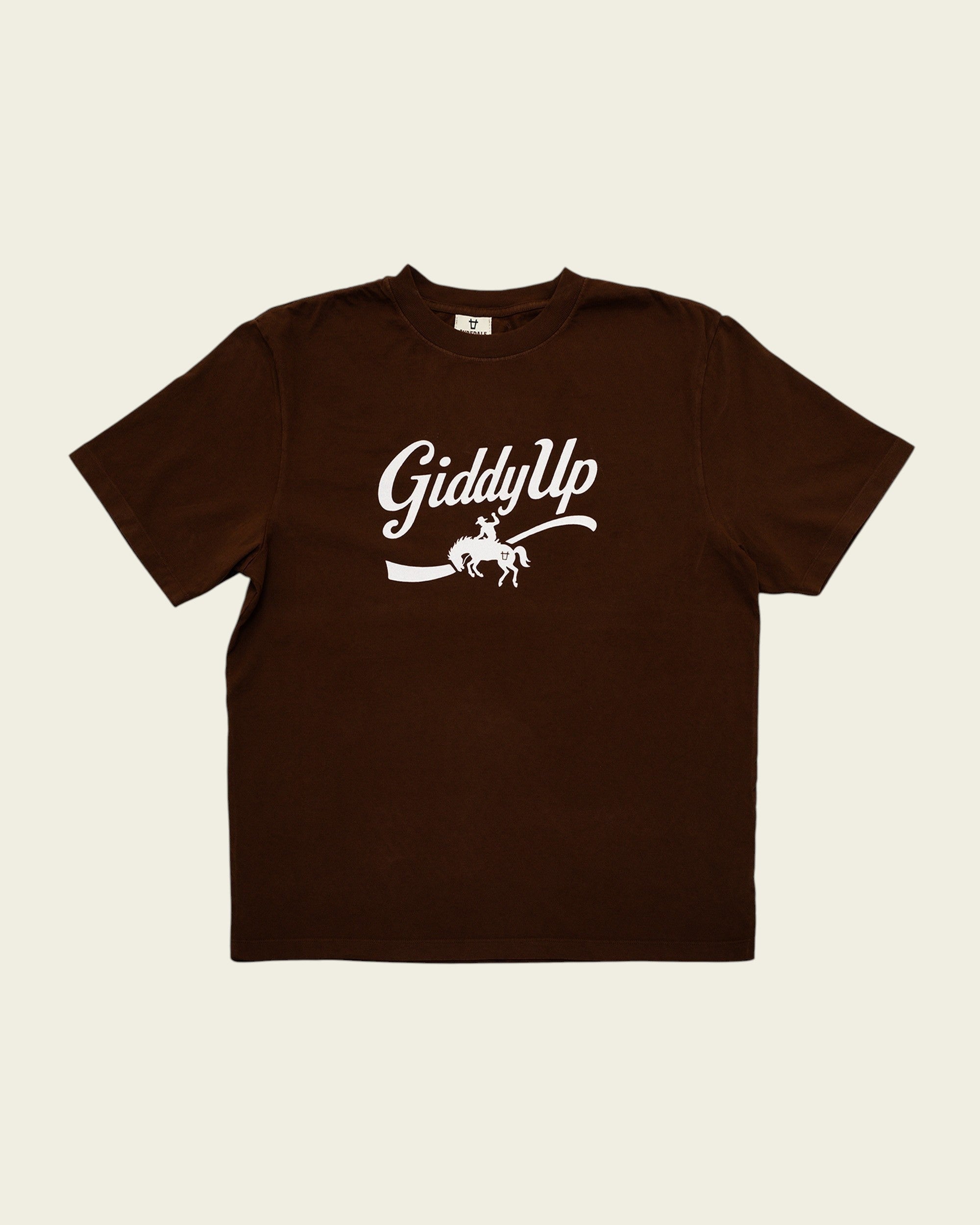 Ayredale Ranch & Co brown crew neck t-shirt featuring a white GiddyUp cowboy graphic on the chest.