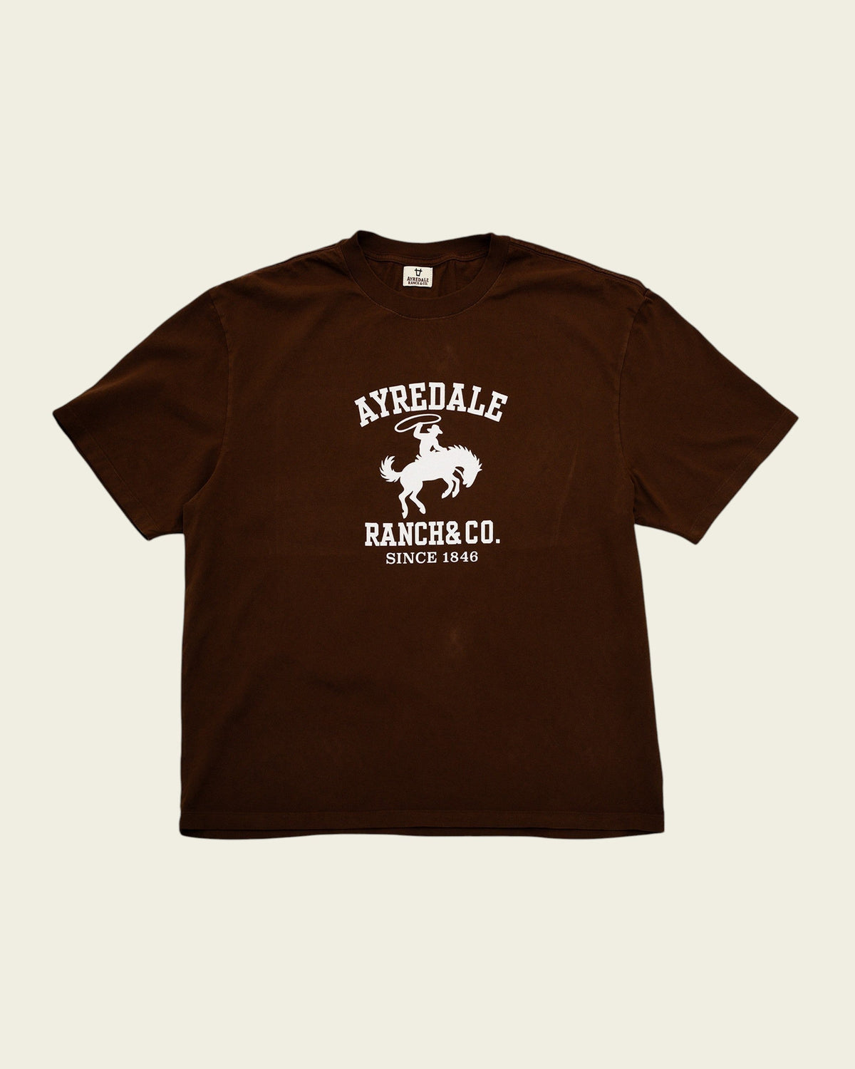Ayredale Ranch & Co brown cotton t-shirt featuring a white graphic of a cowboy on a bucking horse