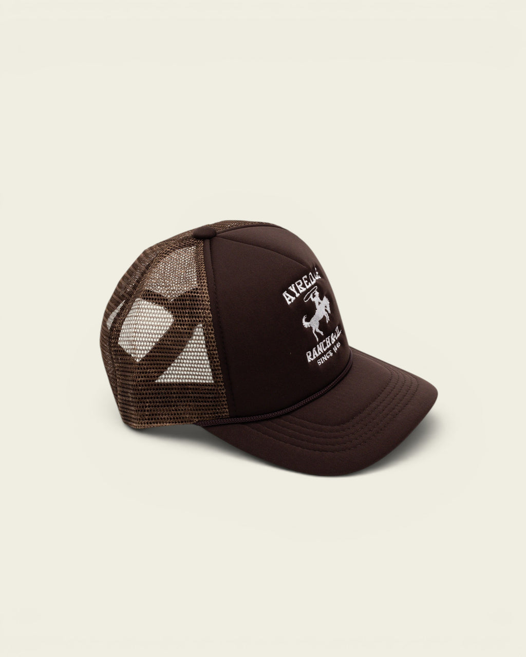 Ayredale Ranch & Co brown trucker hat with mesh back, rope detail, and white embroidered ranch logo on front panel.