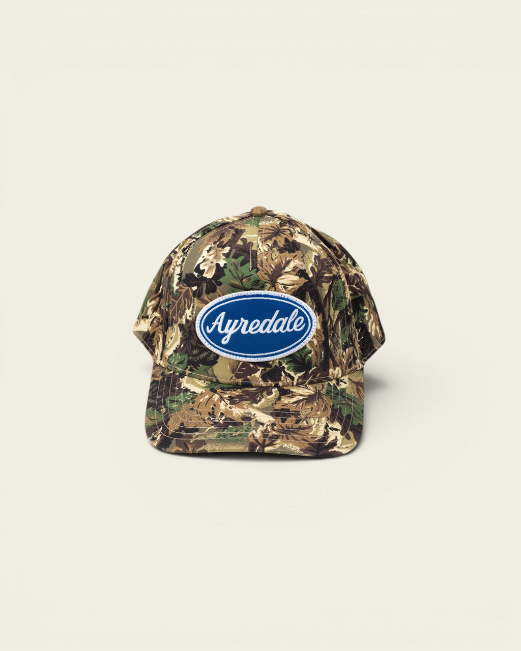 Ayredale Ranch & Co camouflage baseball cap with blue oval logo patch.