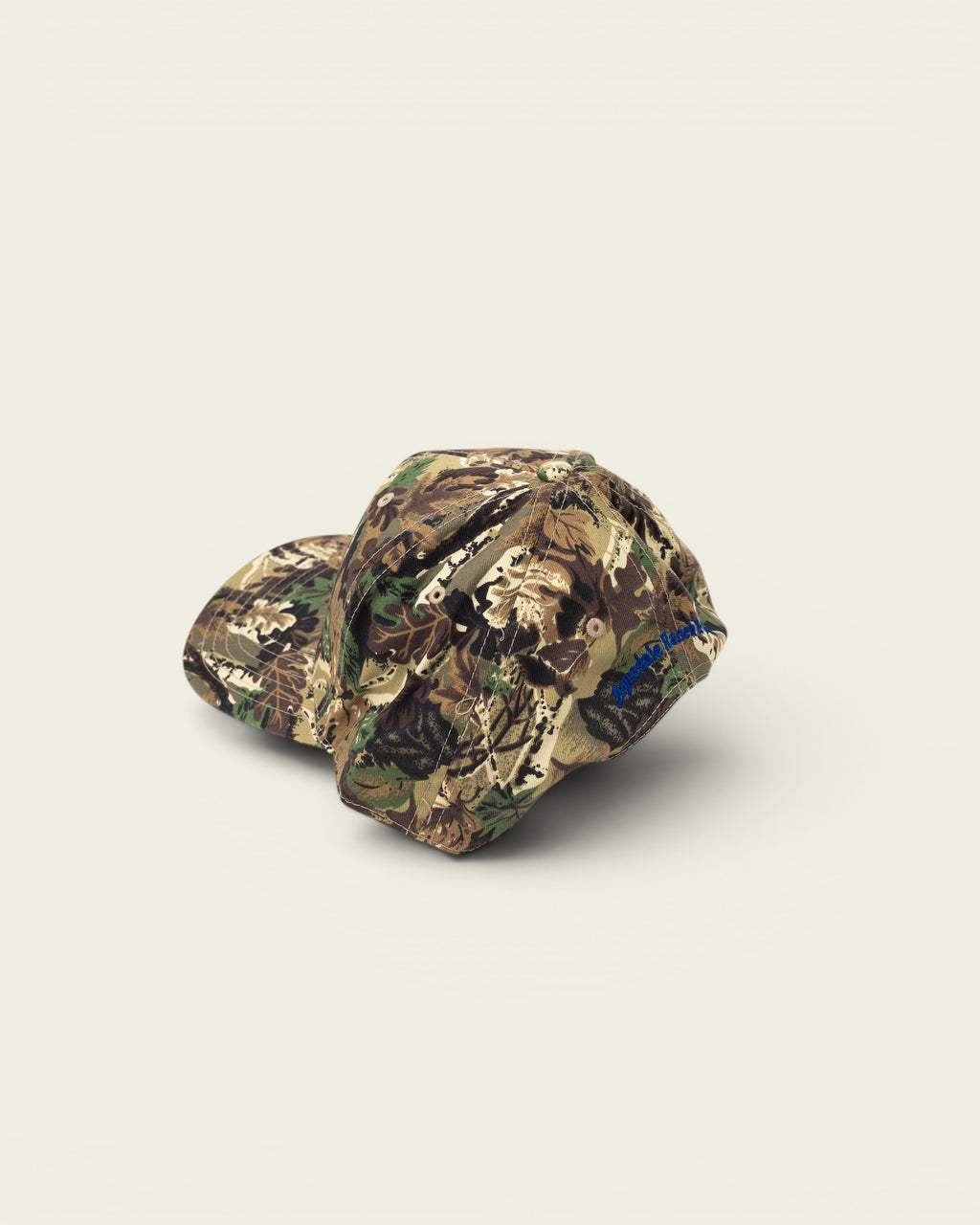 Ayredale Ranch & Co camouflage baseball cap with blue embroidered text on the brim.
