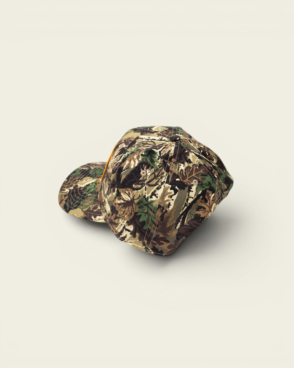 Ayredale Ranch & Co camouflage baseball cap with a flat brim and orange accent.