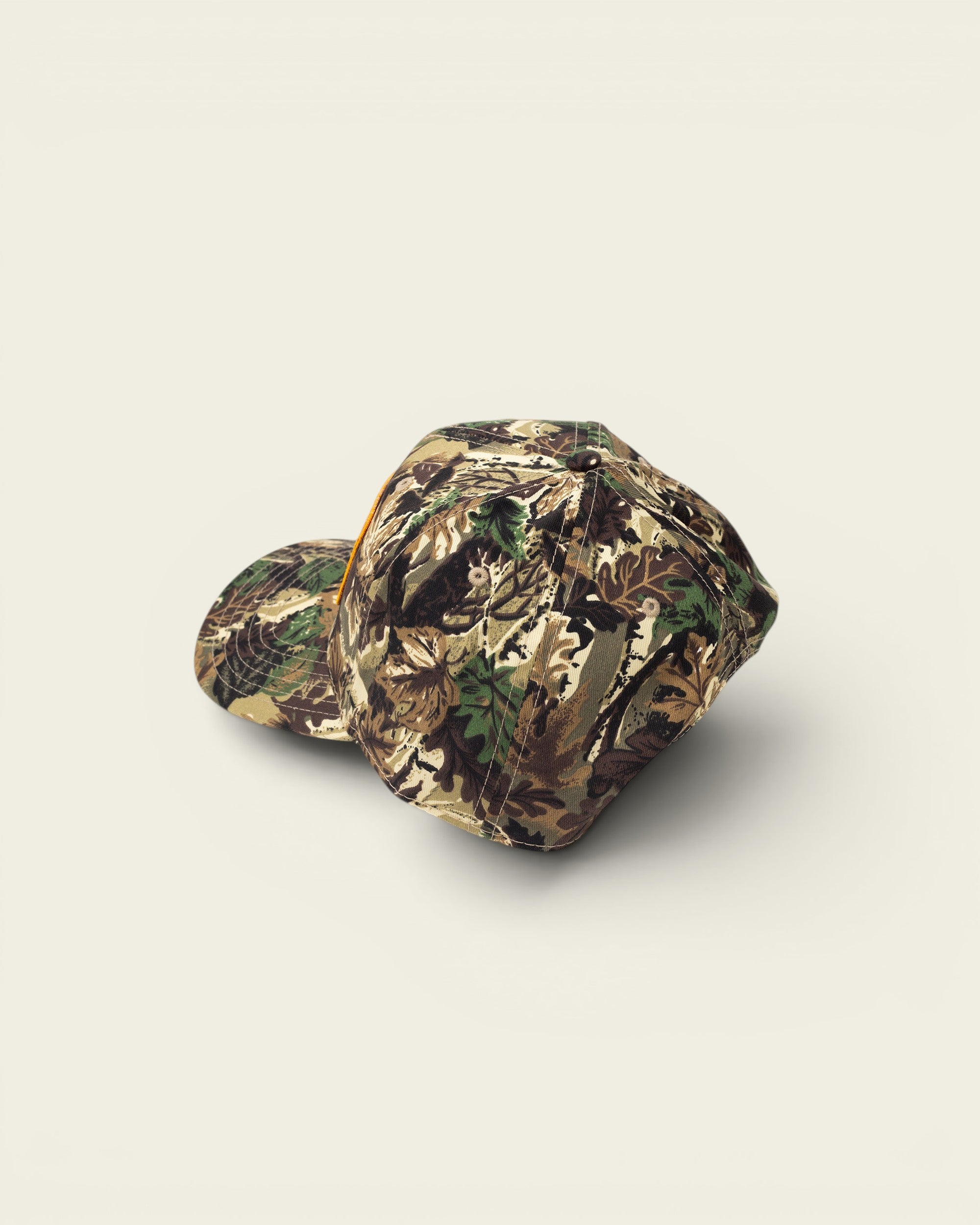 Ayredale Ranch & Co camouflage baseball cap with a flat brim and orange accent.