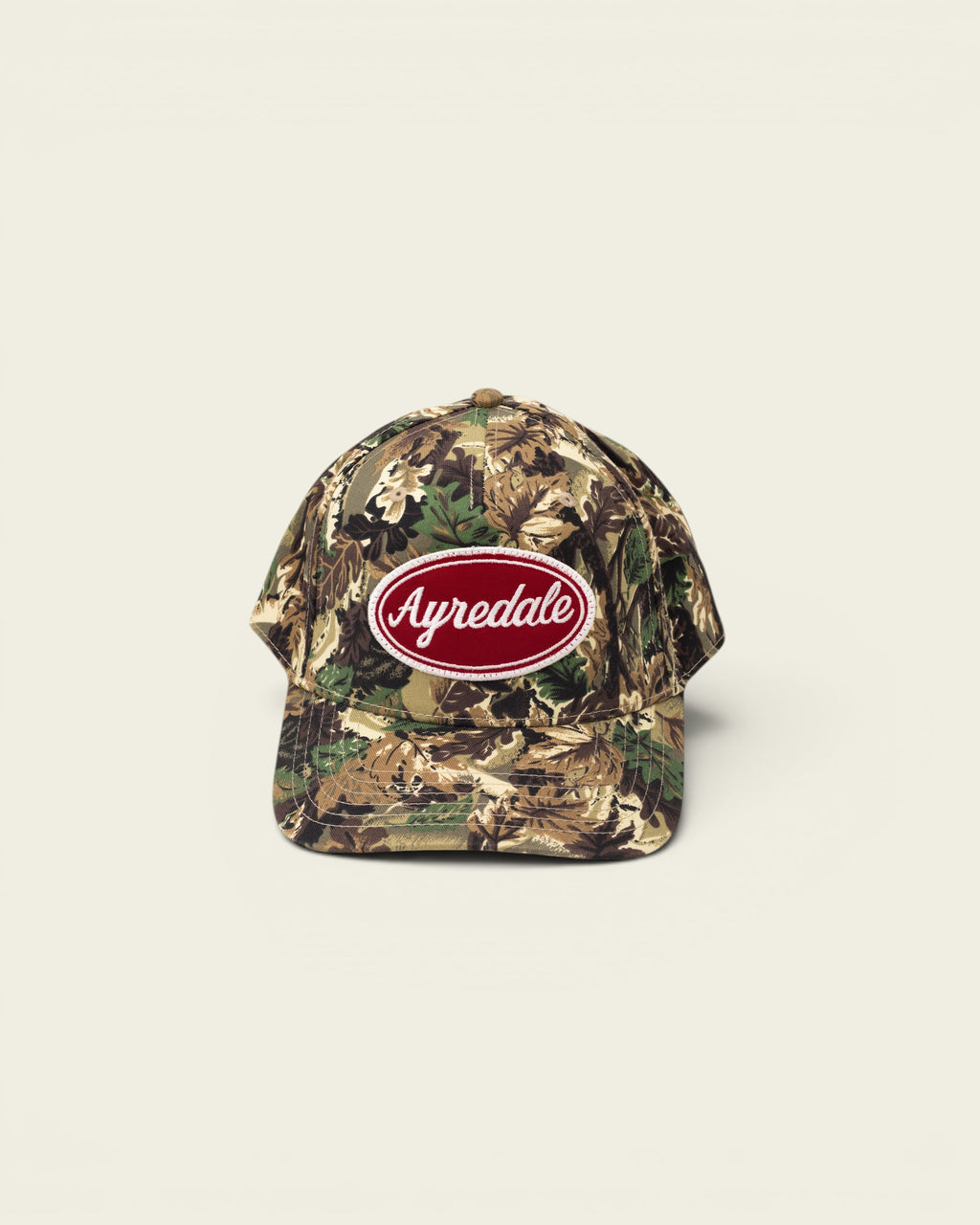 Ayredale Ranch & Co camouflage baseball cap with red oval logo patch.