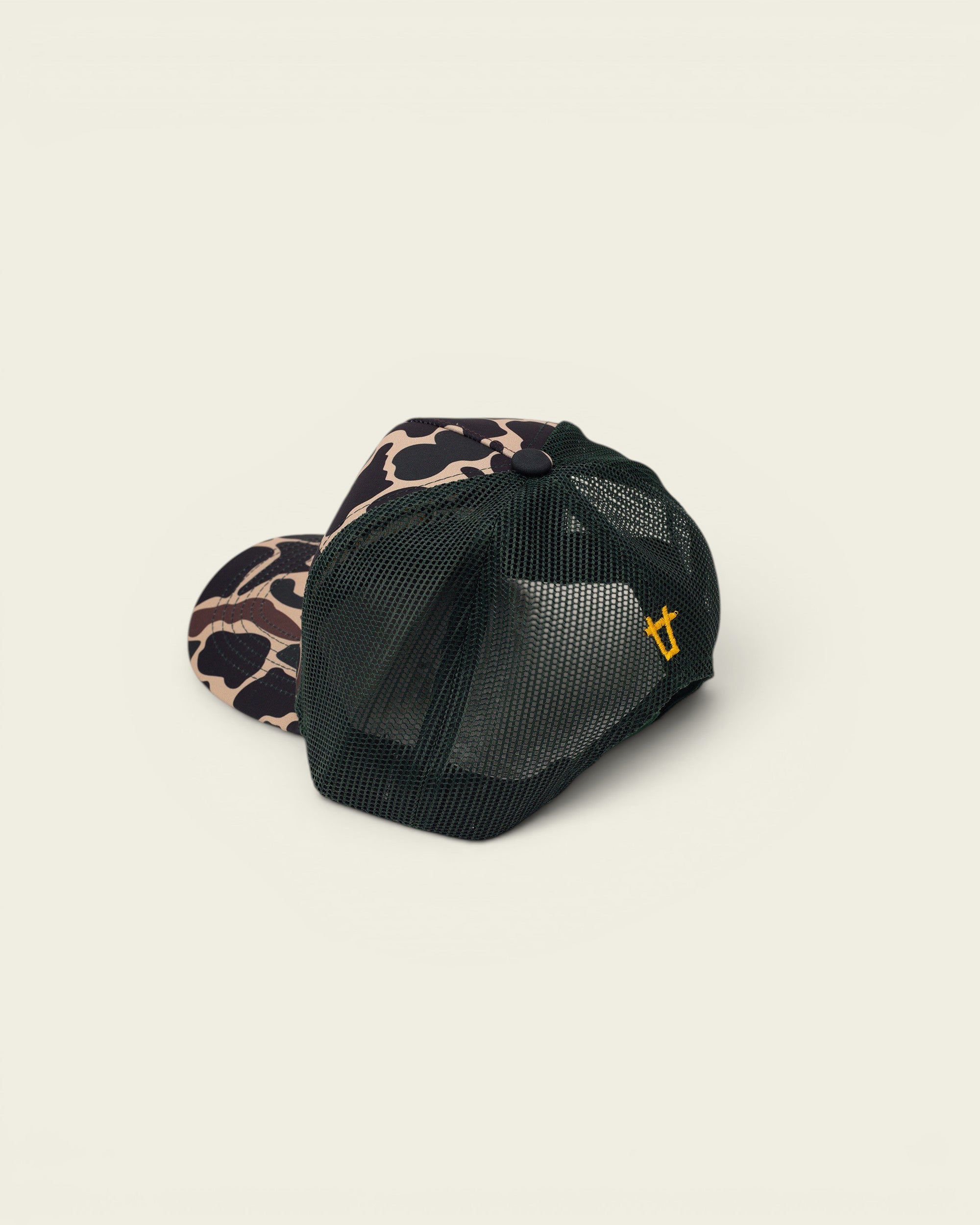 Ayredale Ranch & Co camouflage trucker hat with dark green mesh back and yellow logo detail.