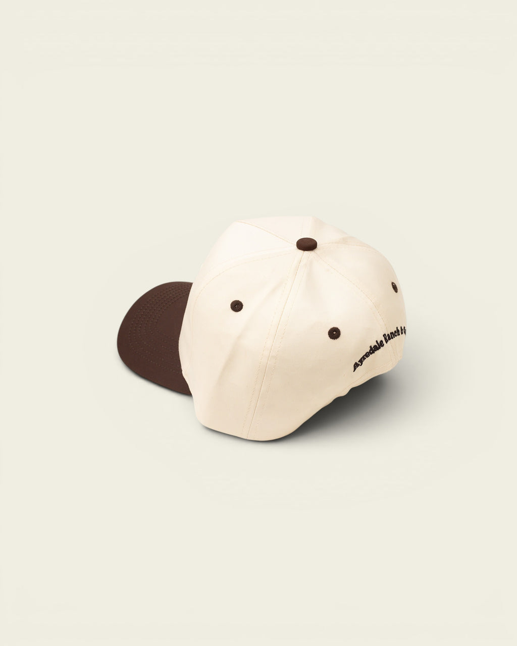 Ayredale Ranch & Co cream baseball cap with brown accents and embroidered logo on the side.
