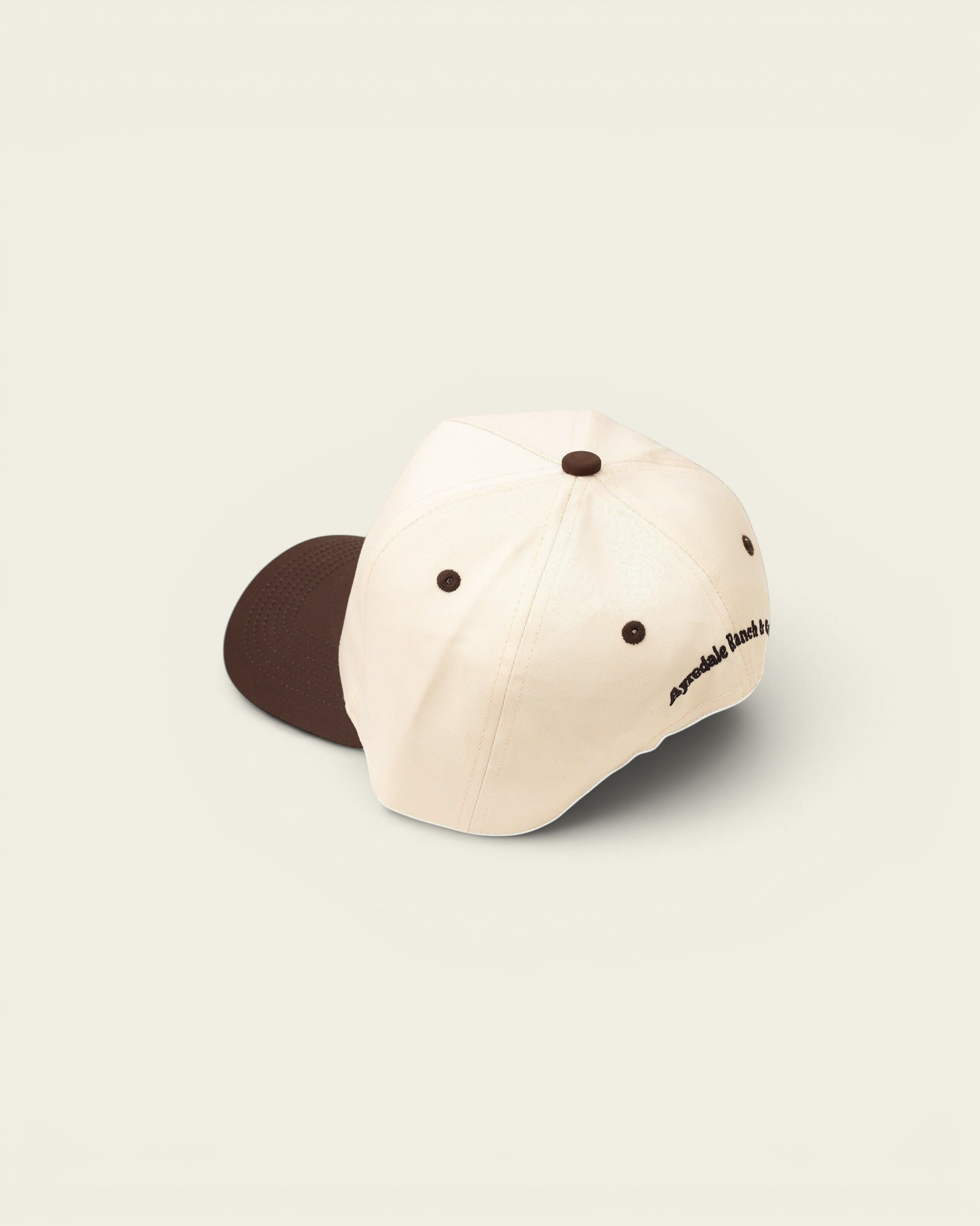 Ayredale Ranch & Co cream baseball cap with brown accents and embroidered logo on the side.