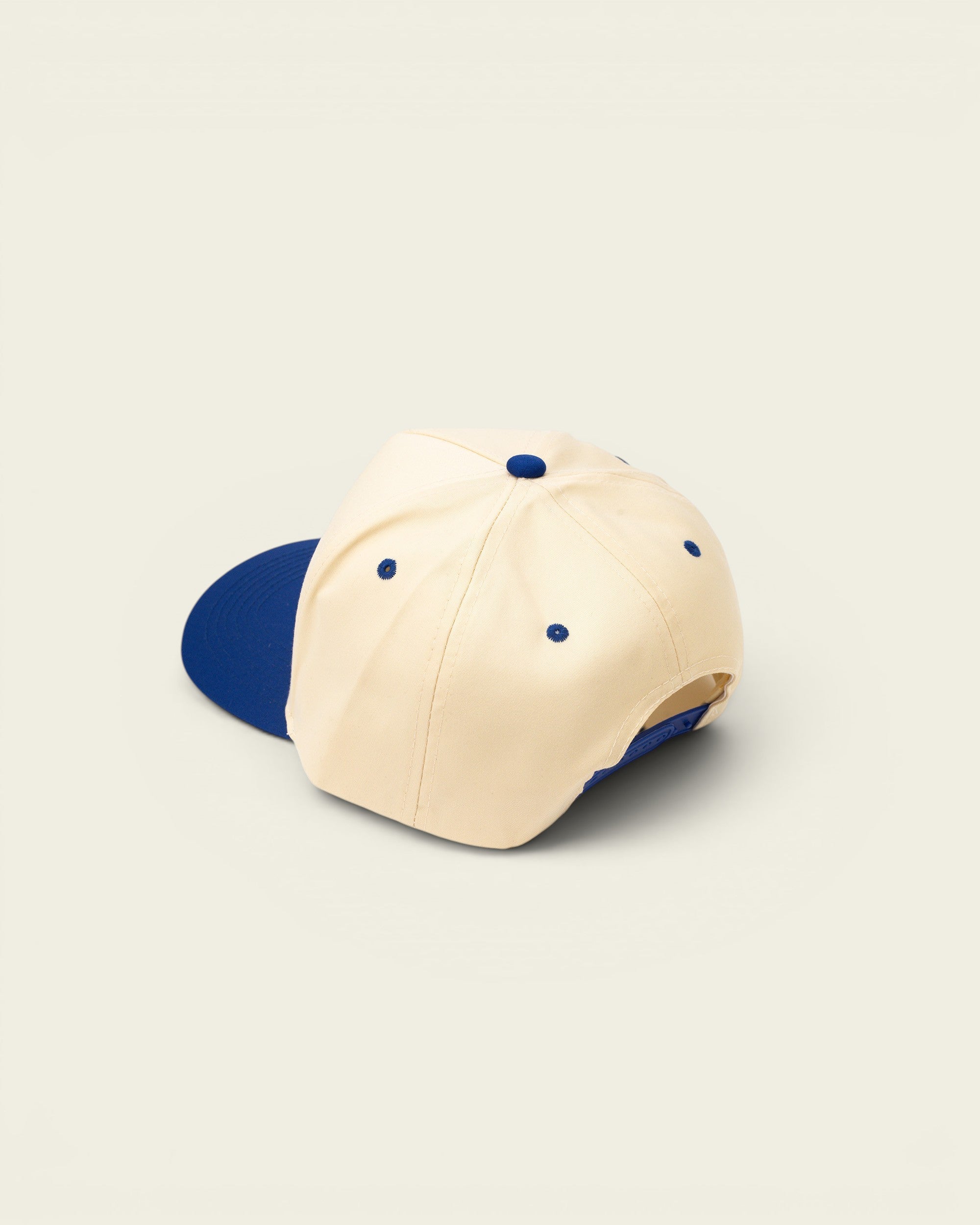 Ayredale Ranch & Co cream baseball cap with blue brim and embroidered details.