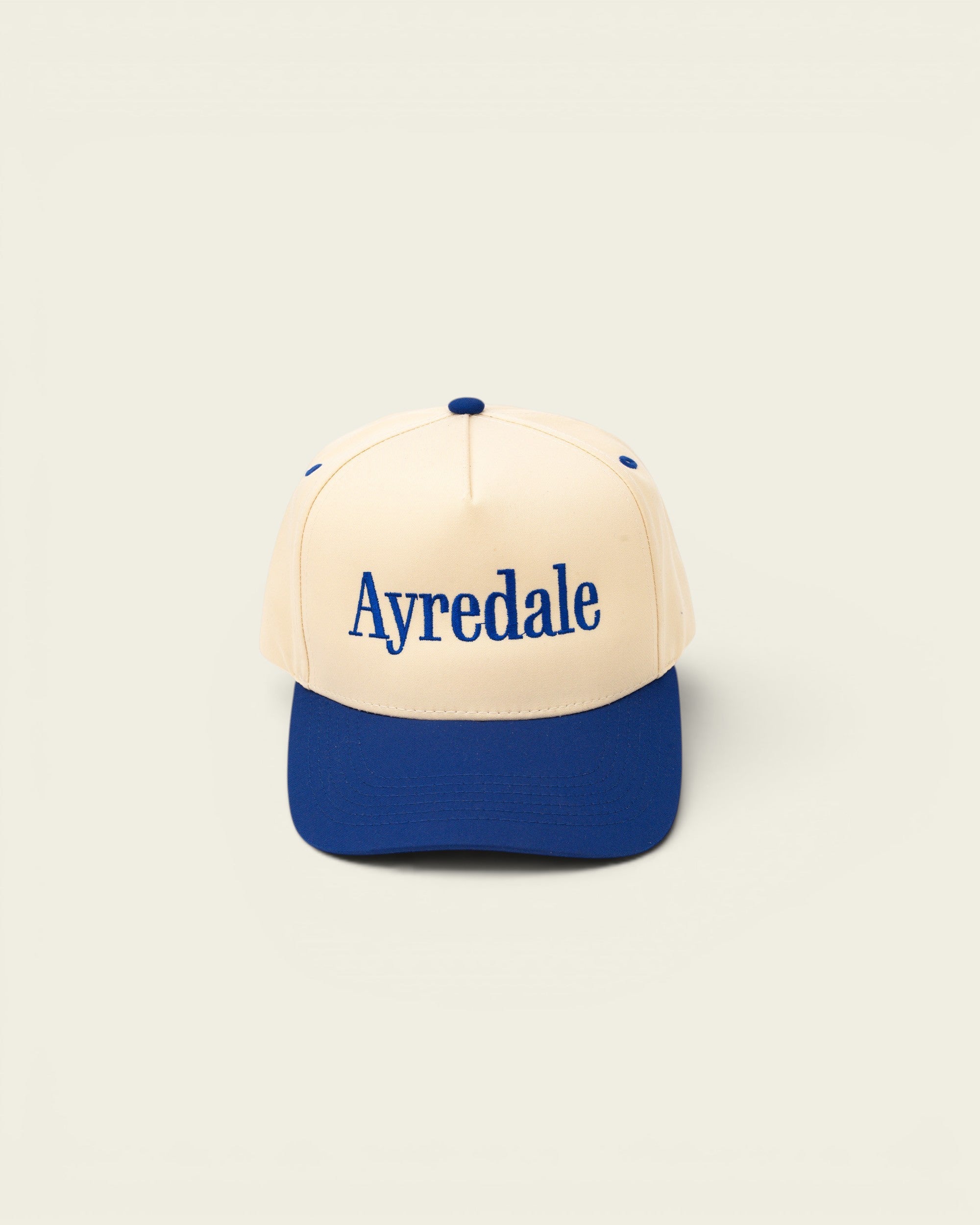 Ayredale Ranch & Co cream baseball cap with blue brim and embroidered Ayredale logo.