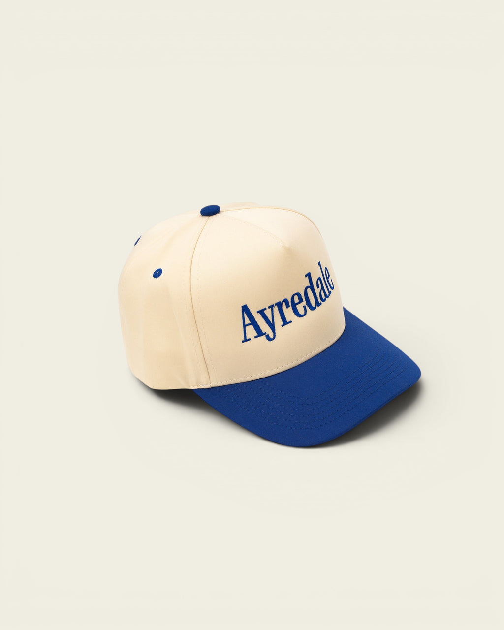 Ayredale Ranch & Co baseball cap in cream with blue brim and embroidered logo.