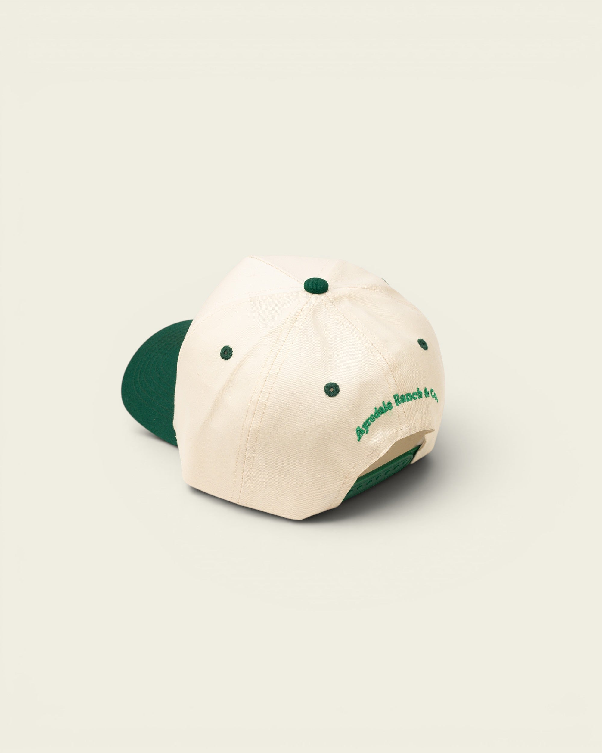 Ayredale Ranch & Co cream baseball cap with green brim and embroidered logo on back