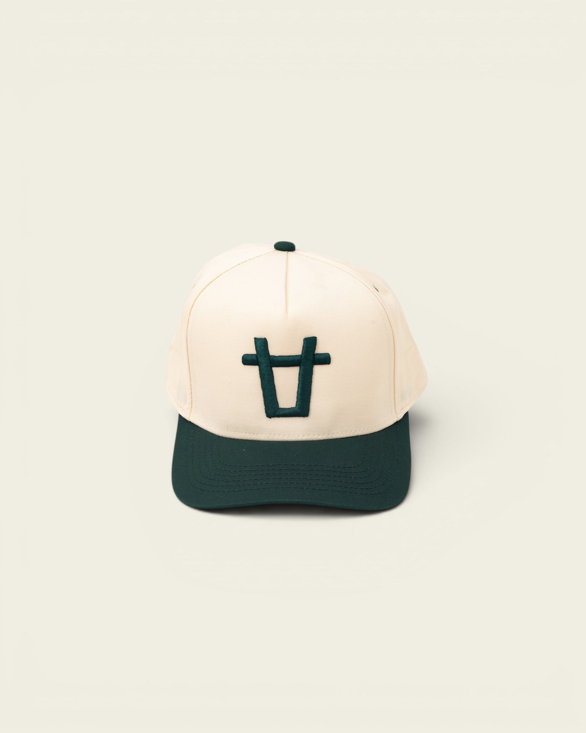 Ayredale Ranch & Co cream baseball cap with dark green brim and embroidered bull logo on the front.
