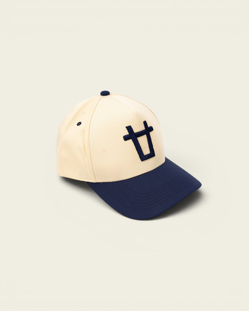 Ayredale Ranch & Co cream baseball cap with navy blue brim and embroidered bull logo.