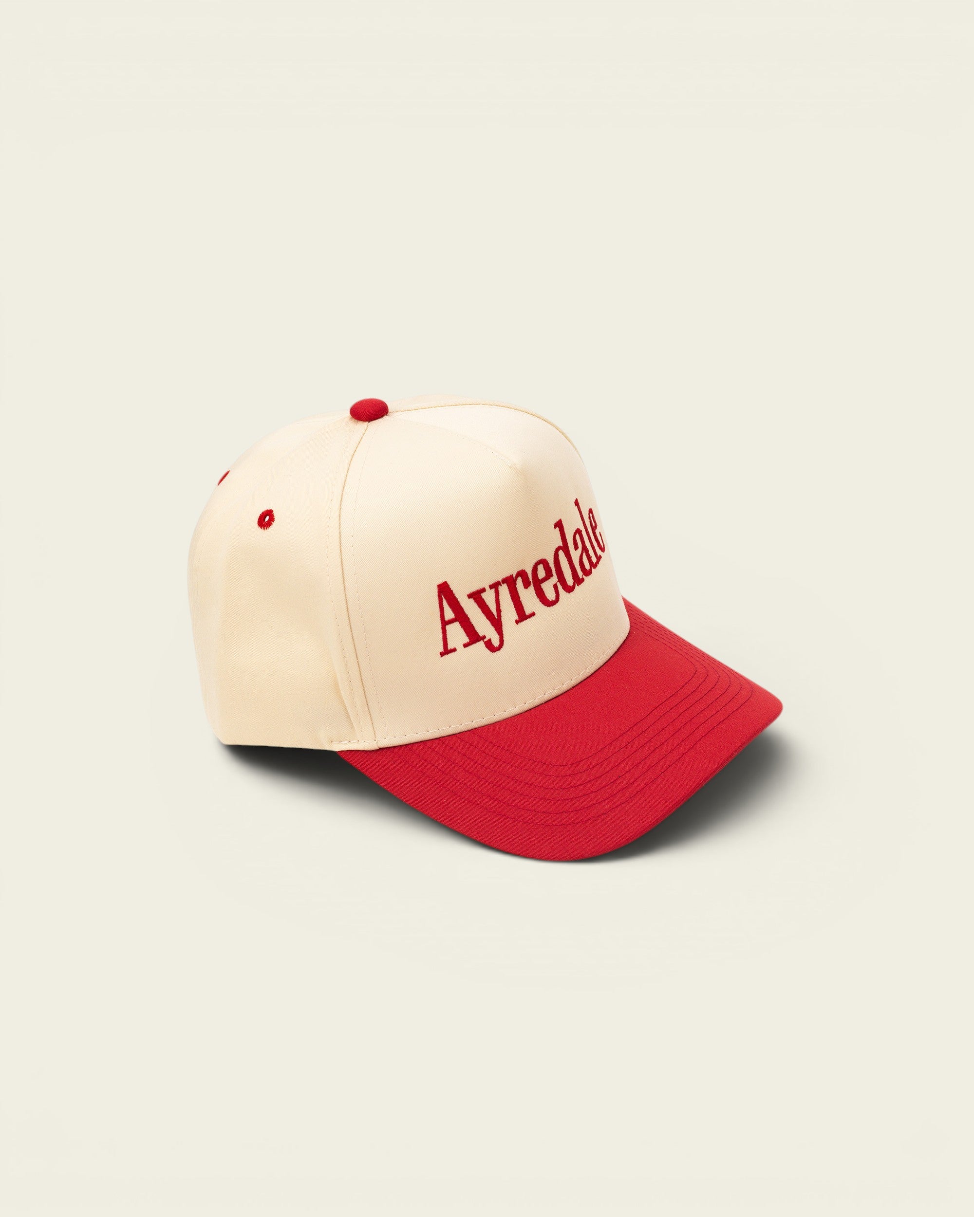 Ayredale Ranch & Co cream baseball cap with red brim and red embroidered logo.