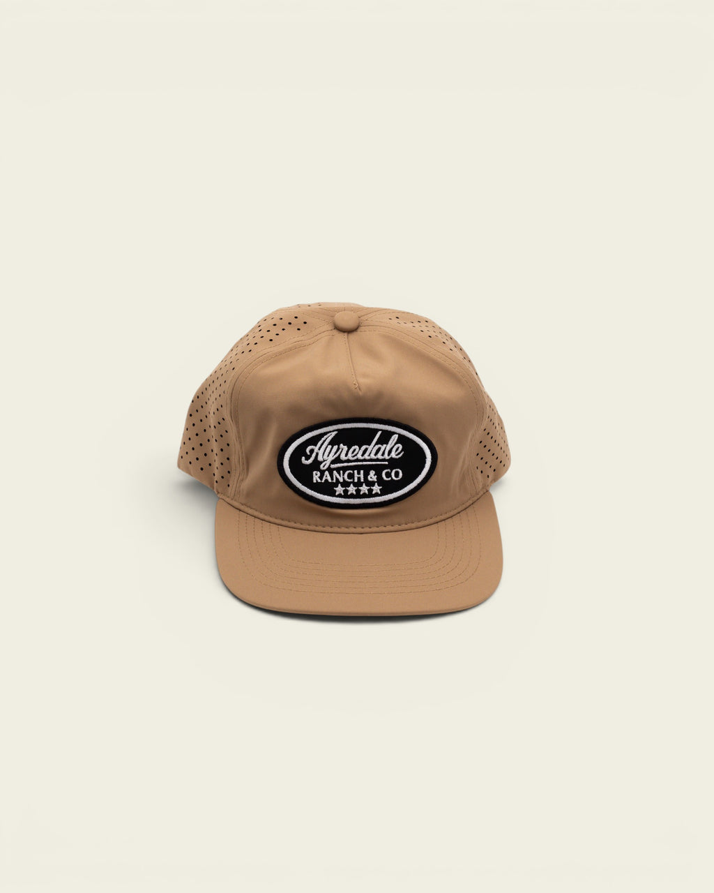 Ayredale Ranch & Co cream performance sport cap with laser-cut ventilation holes and a black oval logo patch