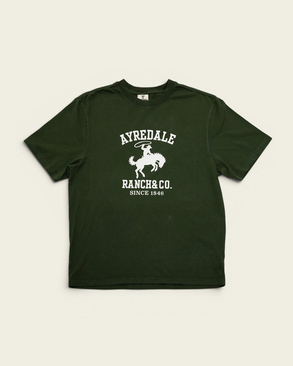 Ayredale Ranch & Co dark green cotton t-shirt featuring a white graphic of a cowboy on a bucking horse.