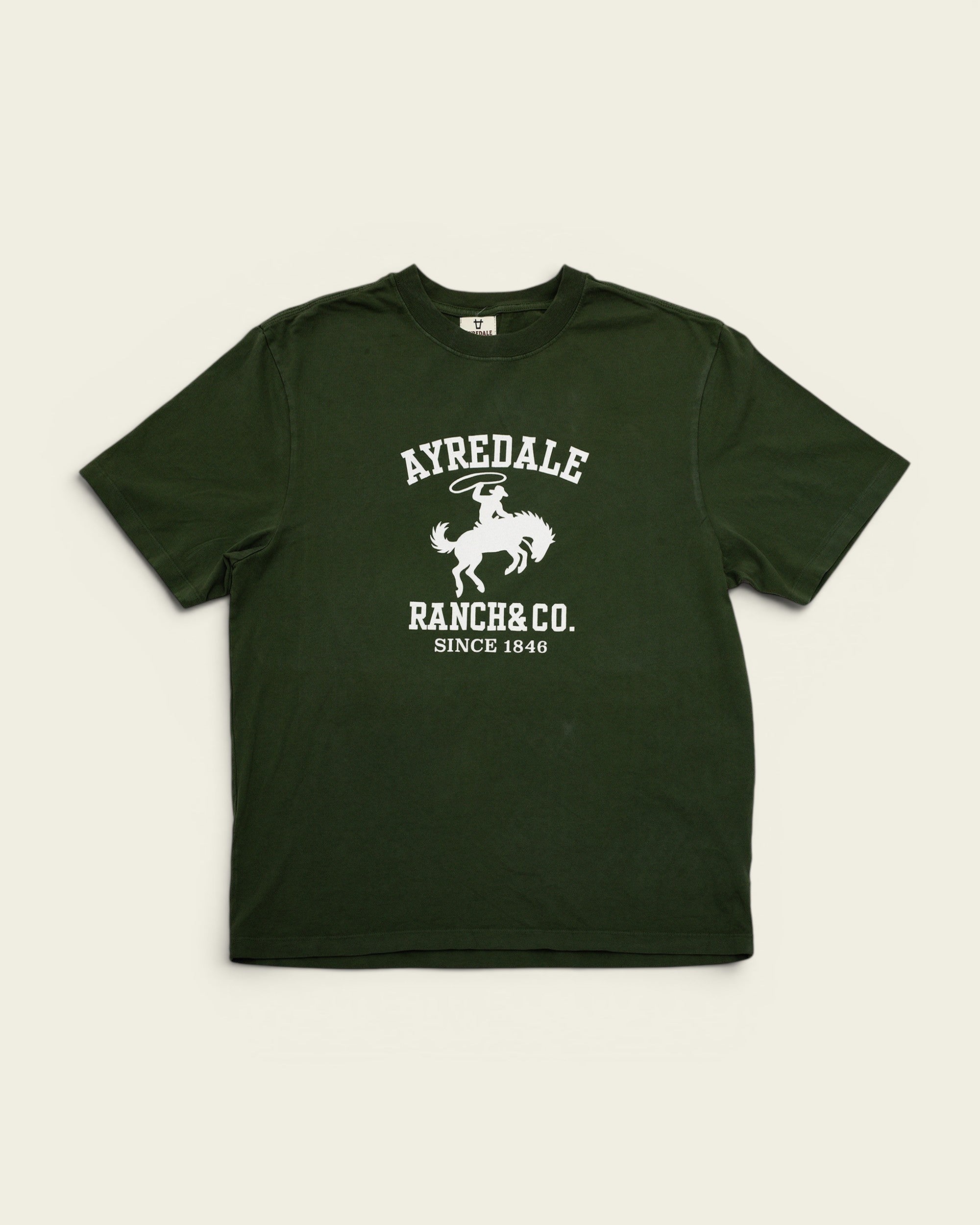 Ayredale Ranch & Co dark green cotton t-shirt featuring a white graphic of a cowboy on a bucking horse.