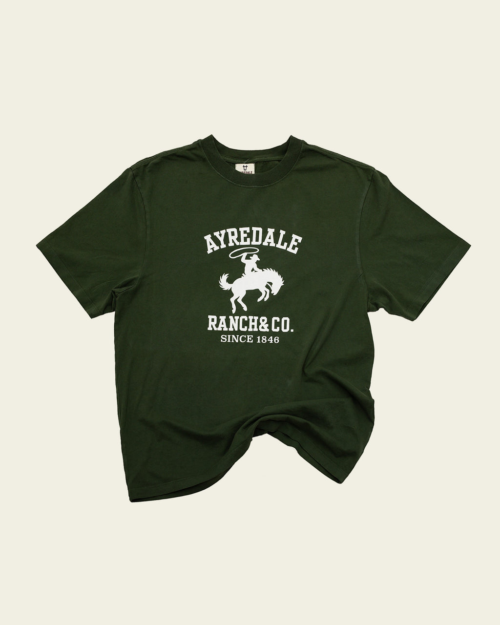 Ayredale Ranch & Co dark green cotton t-shirt featuring a white graphic of a cowboy on a bucking horse