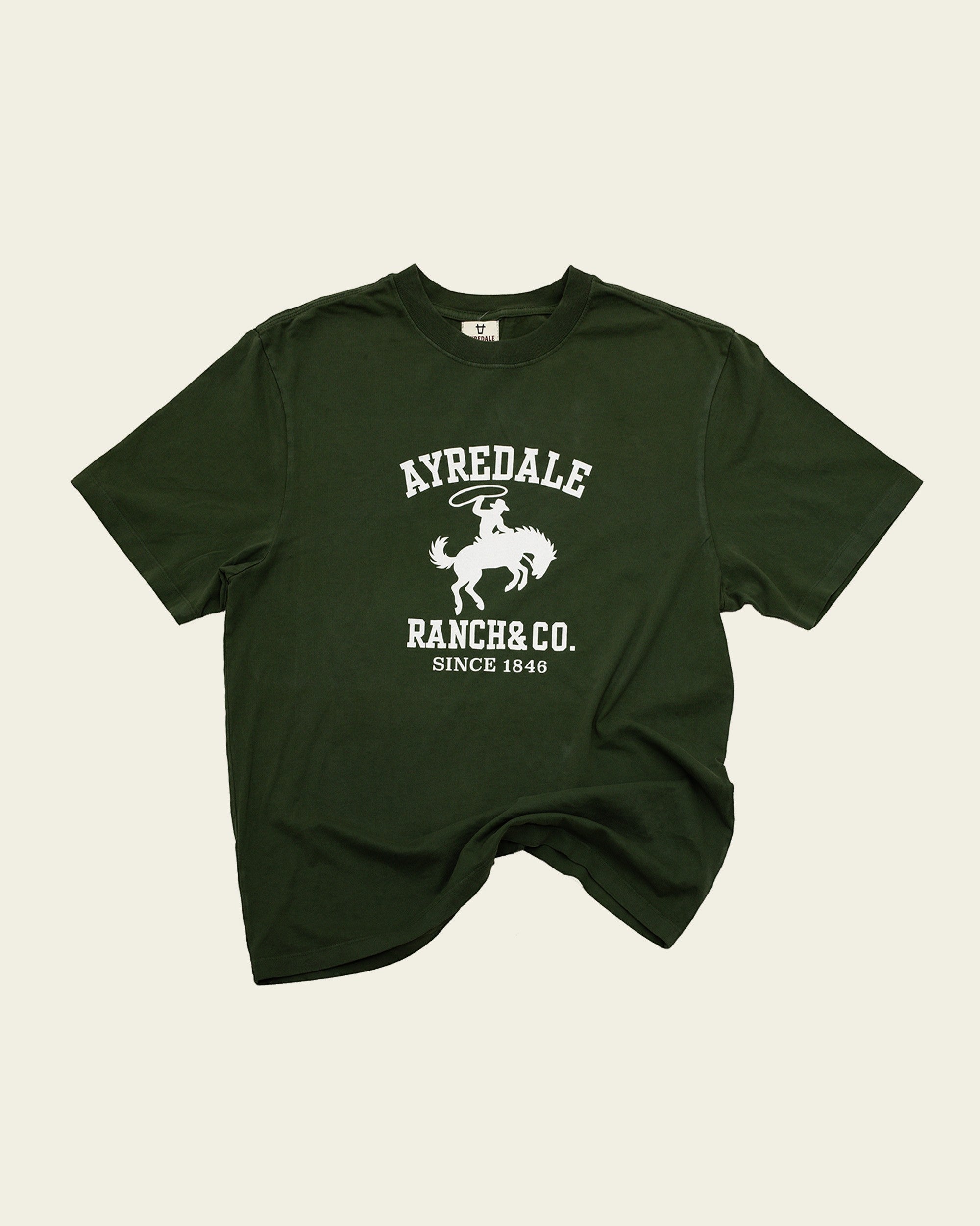 Ayredale Ranch & Co dark green cotton t-shirt featuring a white graphic of a cowboy on a bucking horse