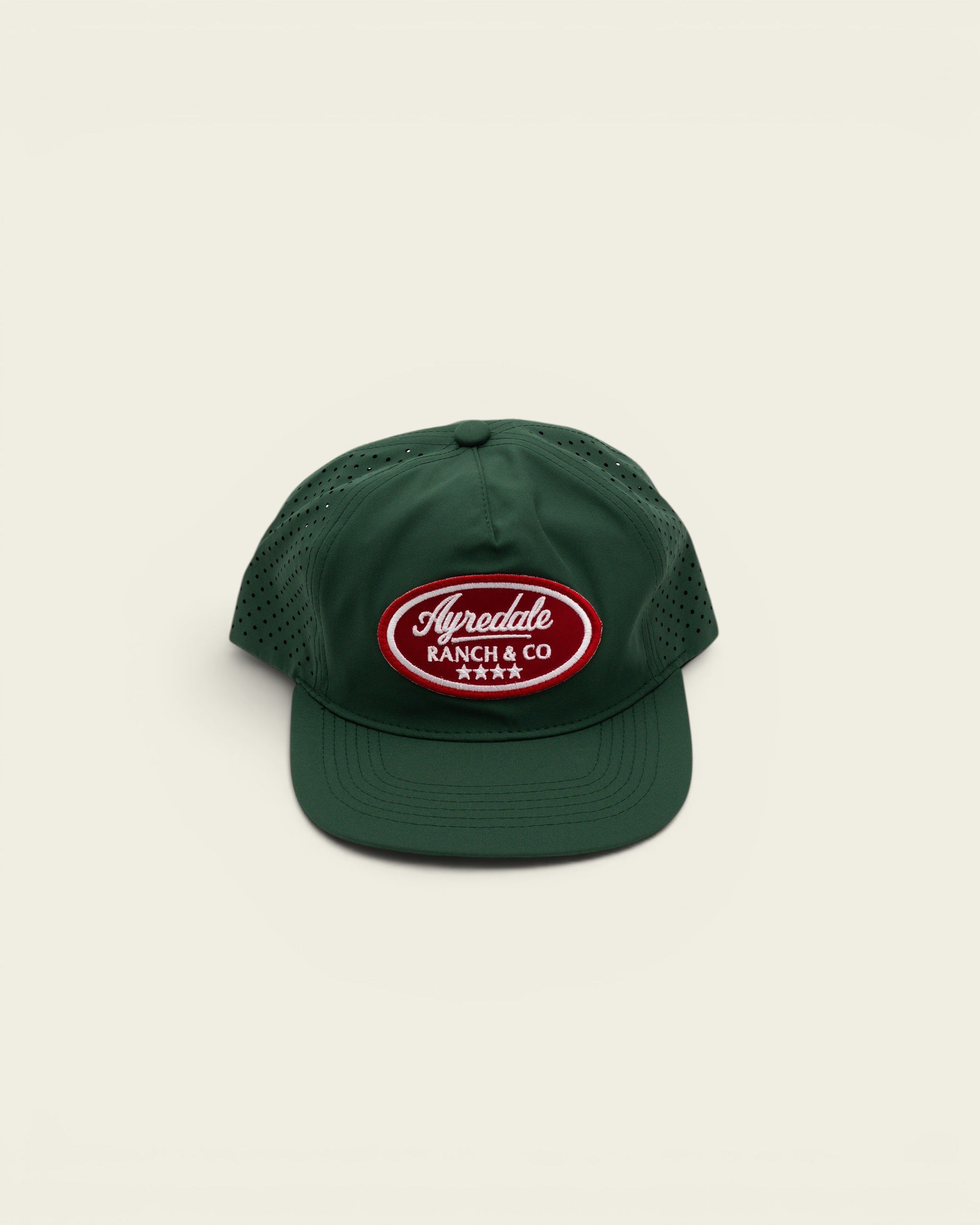 Ayredale Ranch & Co dark green perforated performance baseball cap with a red and white oval logo patch