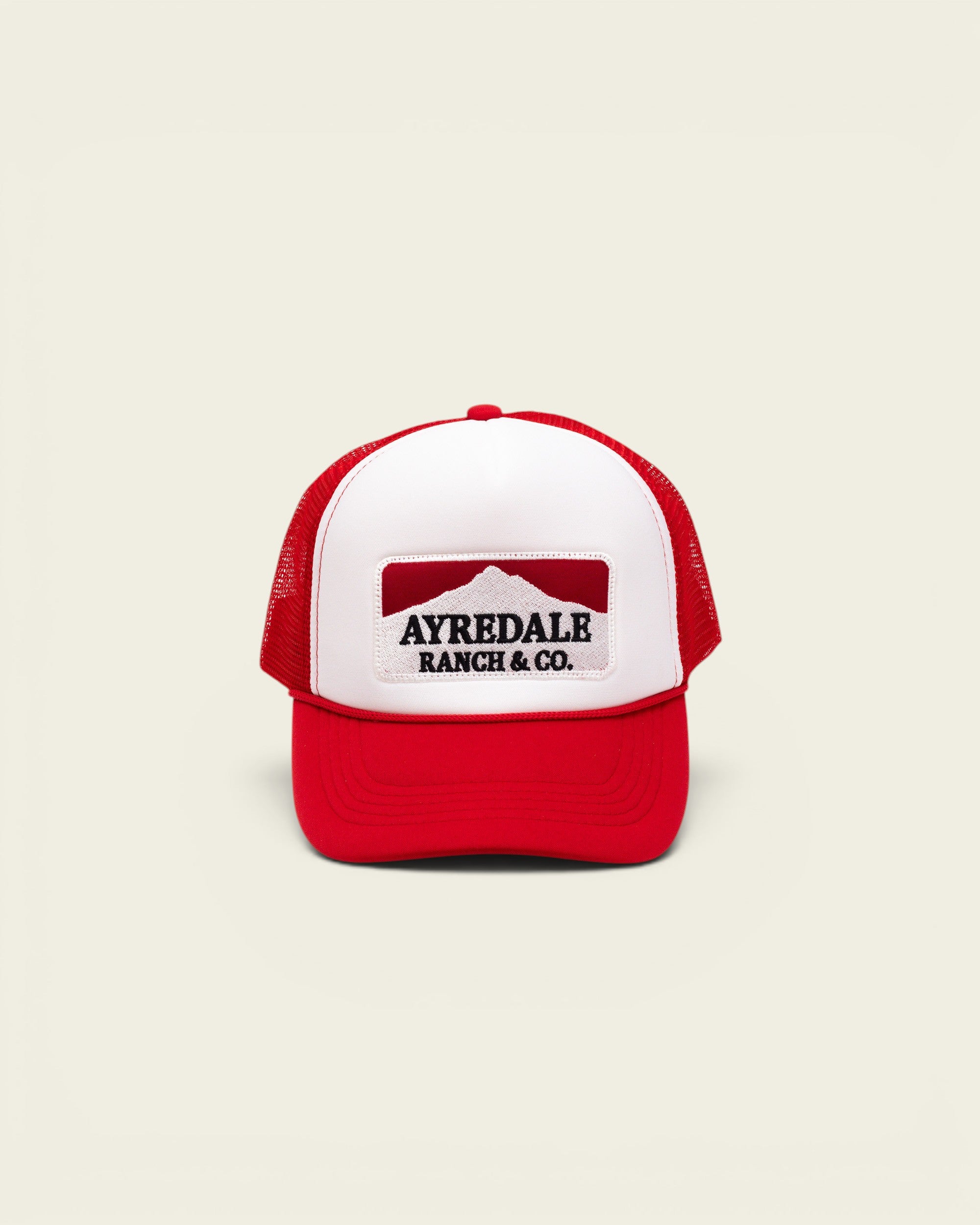 Ayredale Ranch & Co. Mount Warning white and red trucker hat with a mountain graphic patch on the front foam panel.