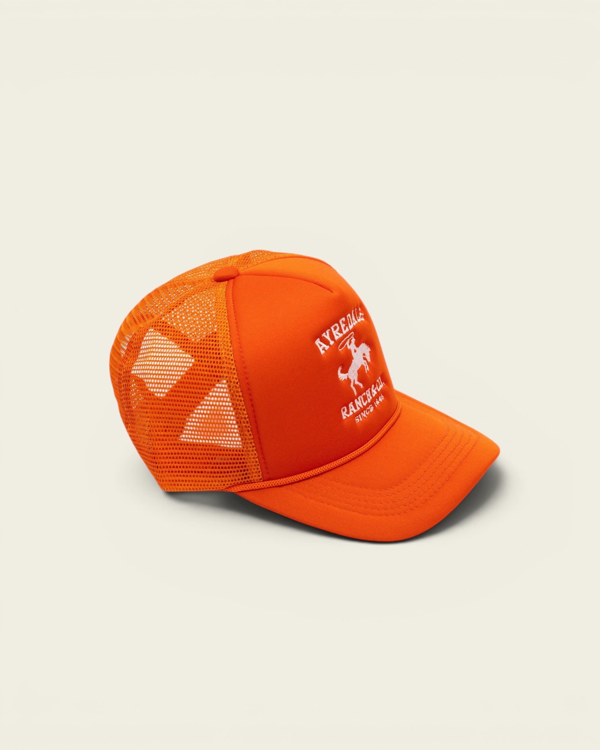 Ayredale Ranch & Co bright orange trucker hat with white logo embroidery and breathable mesh back panel.
