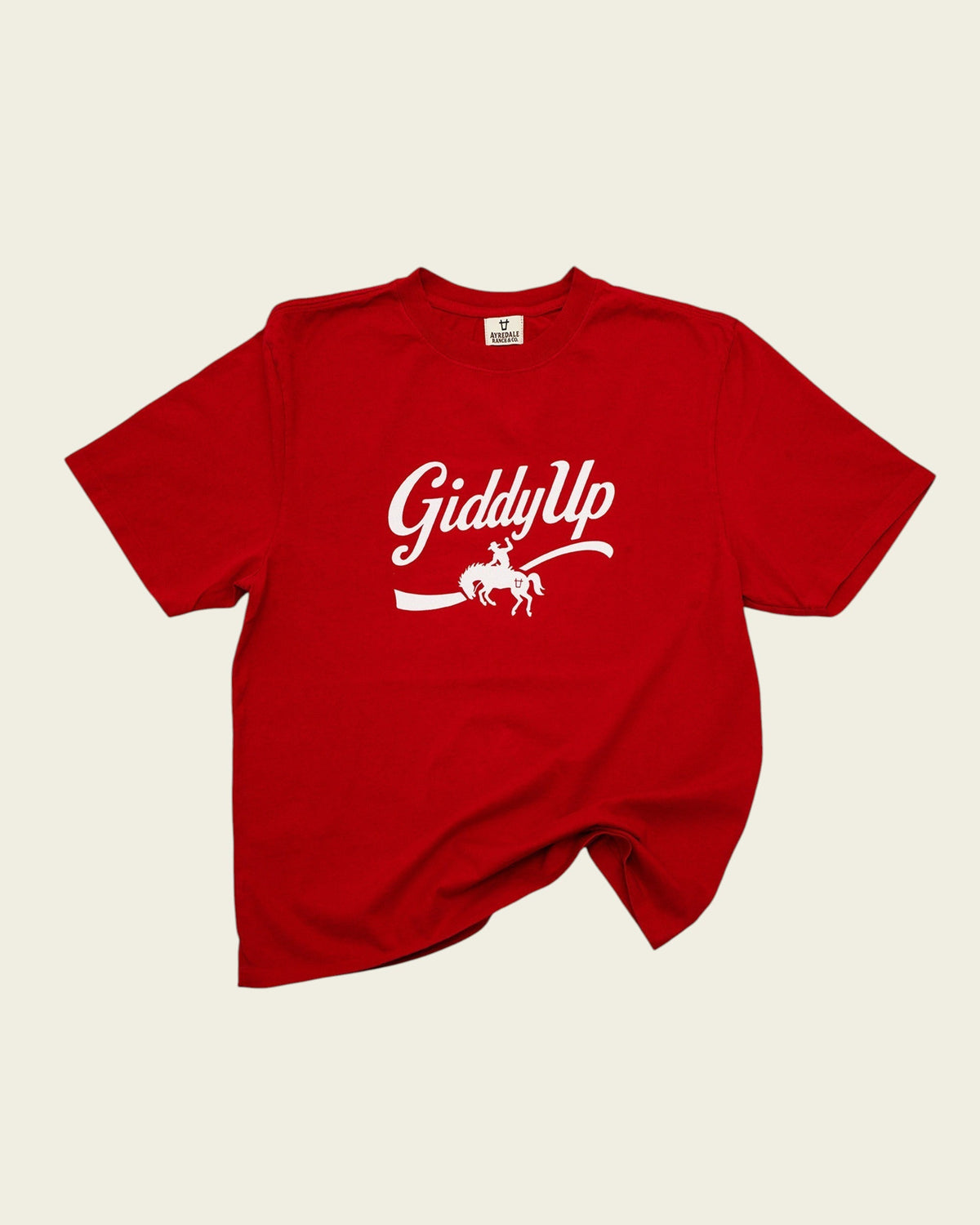 Ayredale Ranch & Co red cotton t-shirt featuring a white Giddy Up graphic with a bucking bronco rider design.