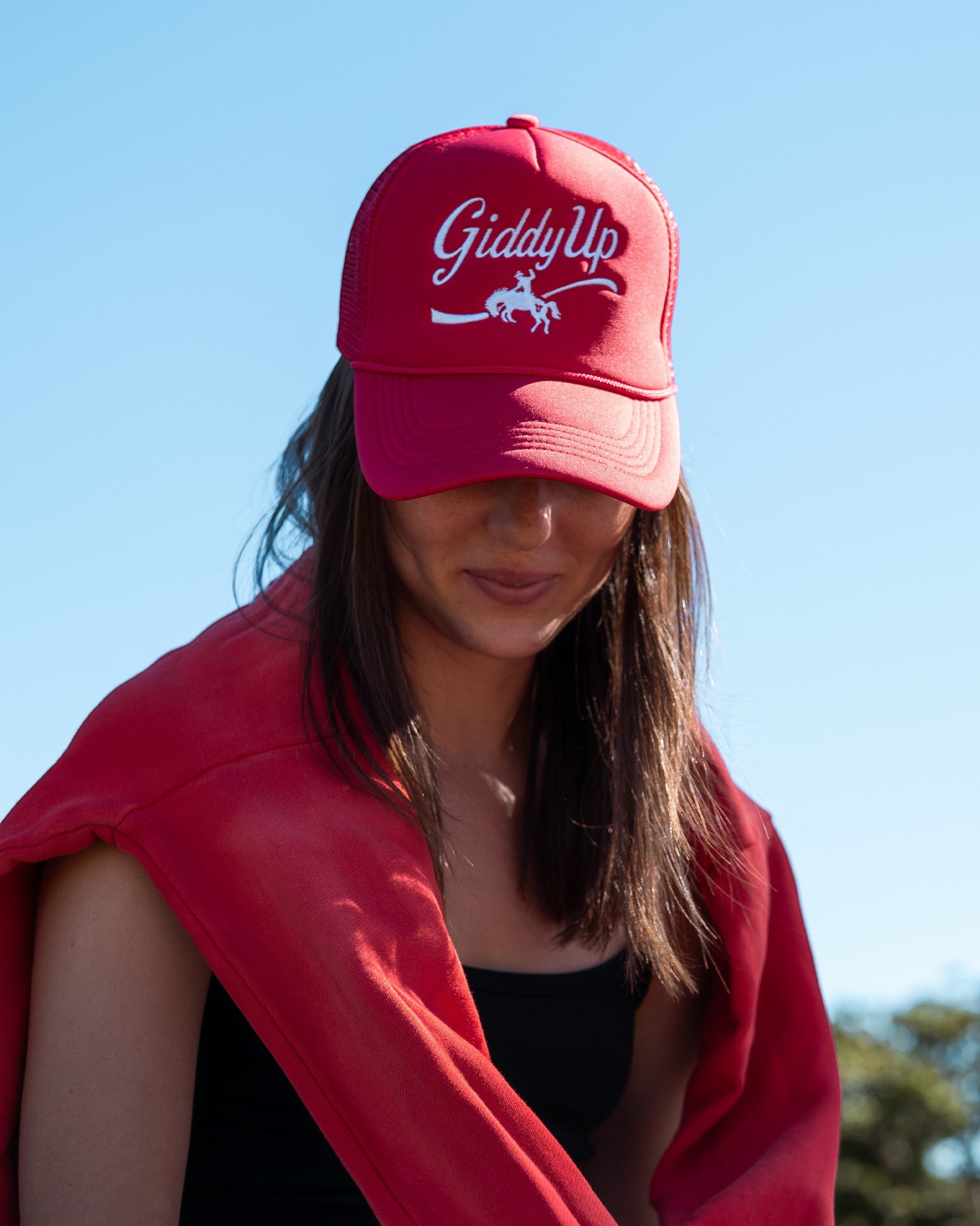 Ayredale Ranch & Co red trucker hat with white "Giddy Up" embroidery and horse graphic