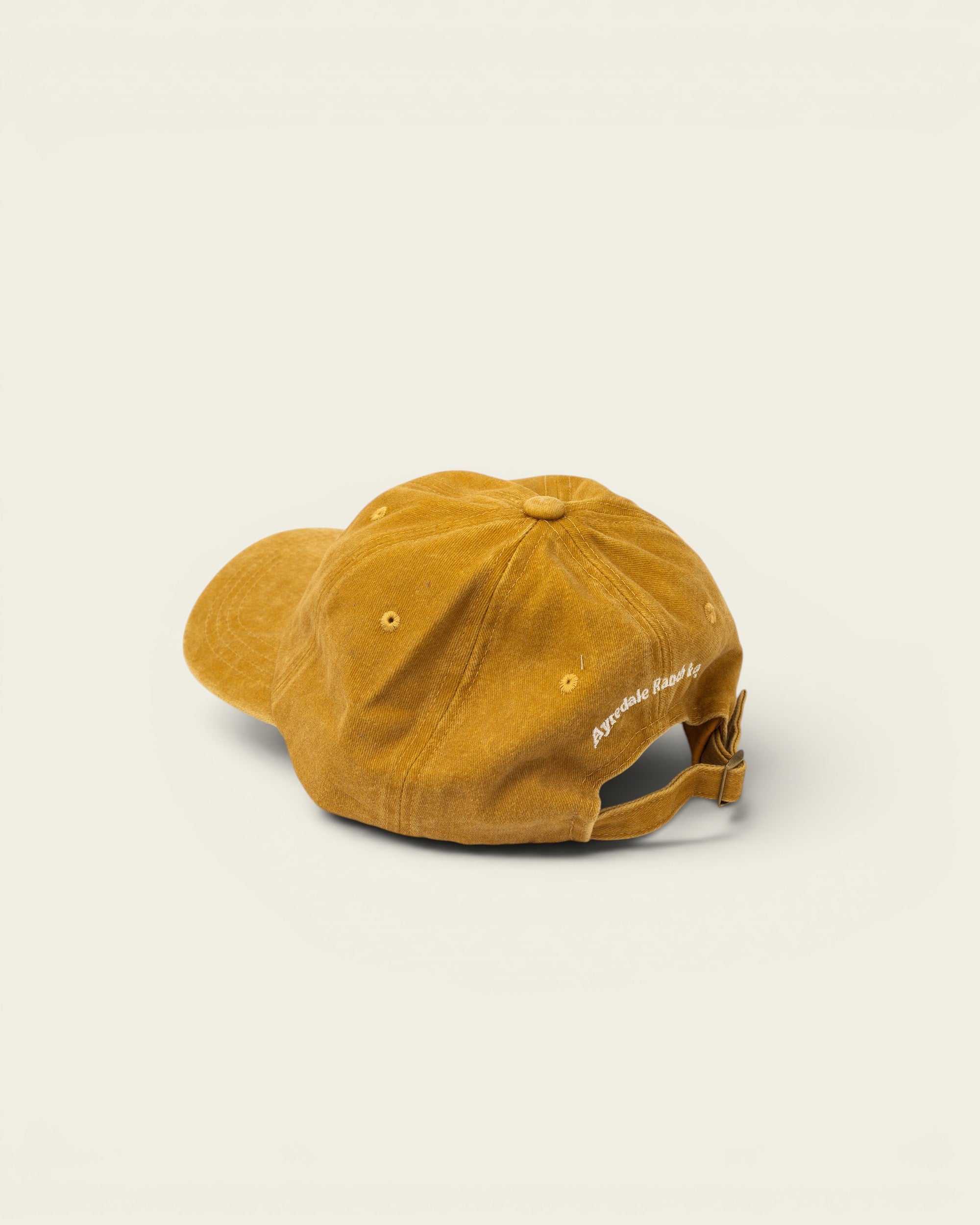 Ayredale Ranch & Co faded yellow corduroy baseball cap with adjustable strap and embroidered logo on back.