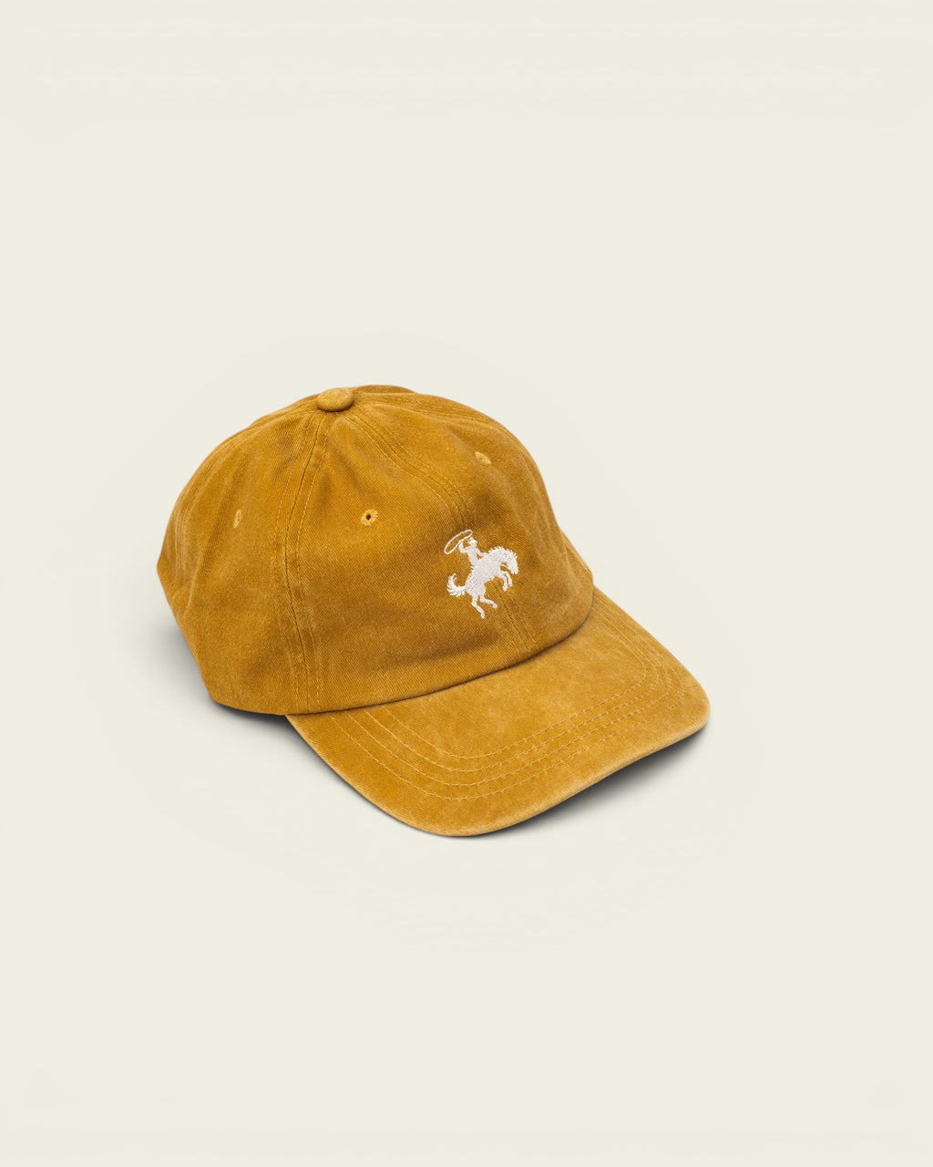 Ayredale Ranch & Co faded yellow cotton baseball cap with white embroidered rodeo rider graphic.